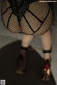 A close up of a woman wearing fishnet stockings and high heels.