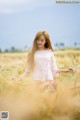 A woman standing in a field of wheat.