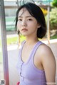 A woman in a purple tank top posing for a picture.